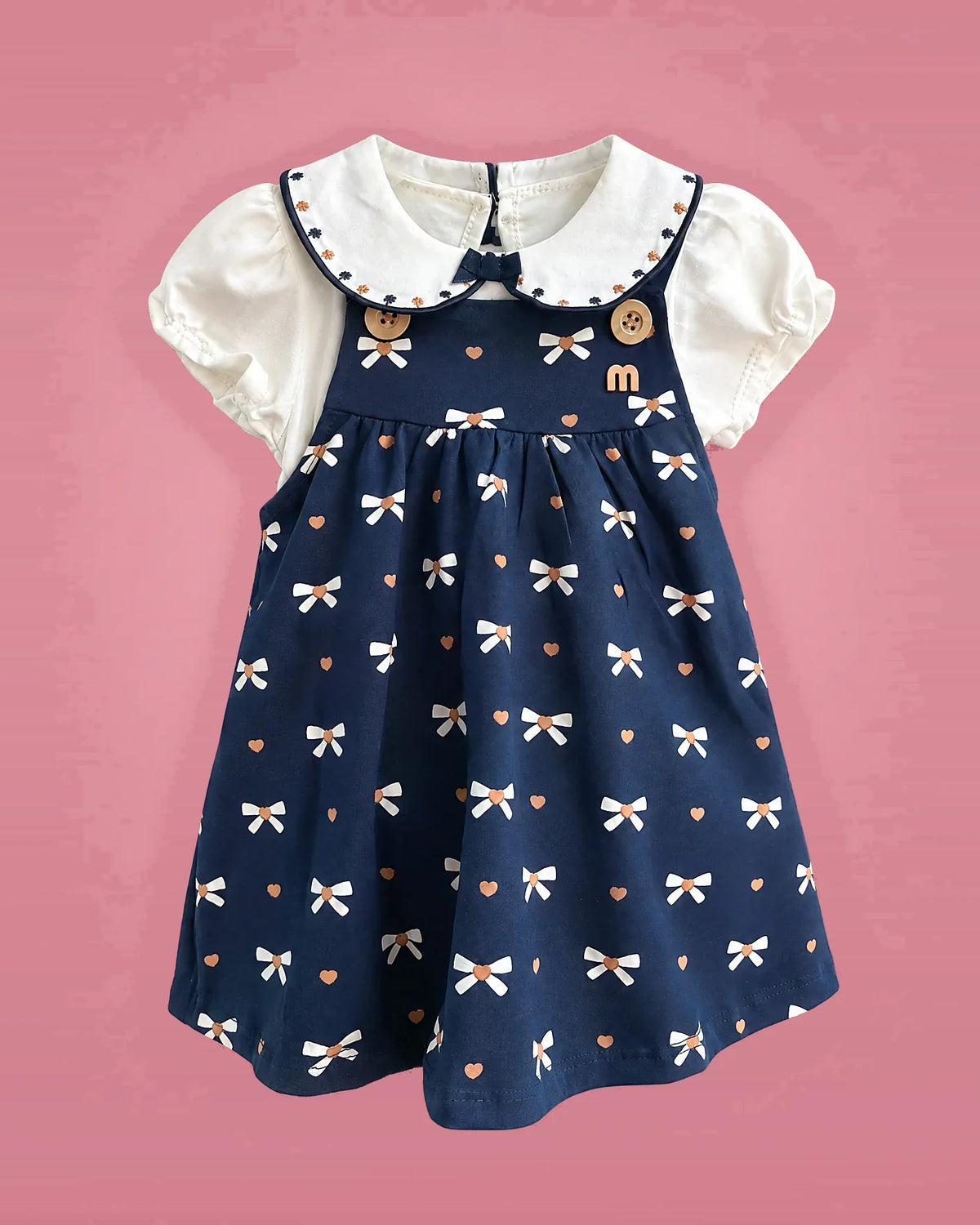 Conjunto de jumper azul marino con lazos y blusa blanca para bebé niña, vista de frente | JR Baby Center