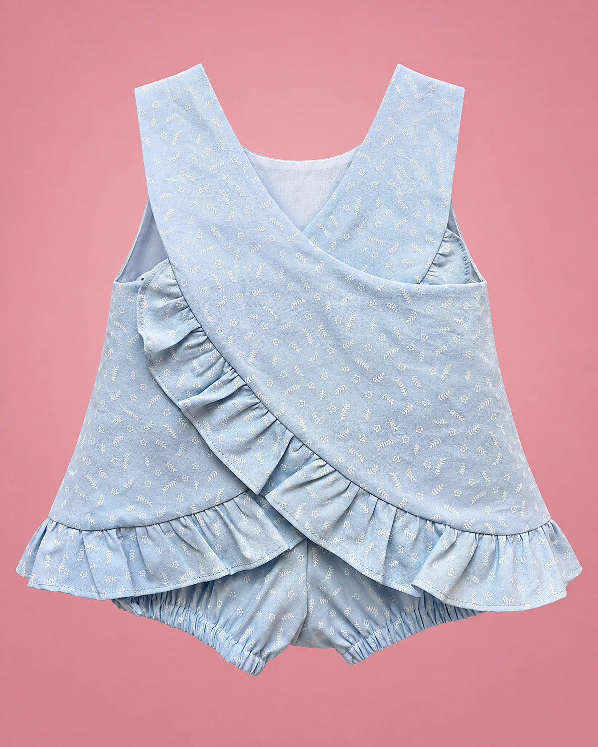 Jumper celeste con bolsillo, volantes y espalda cruzada para bebé niña, vista de espalda | JR Baby Center