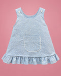 Jumper celeste con bolsillo, volantes y espalda cruzada para bebé niña, vista de frente | JR Baby Center