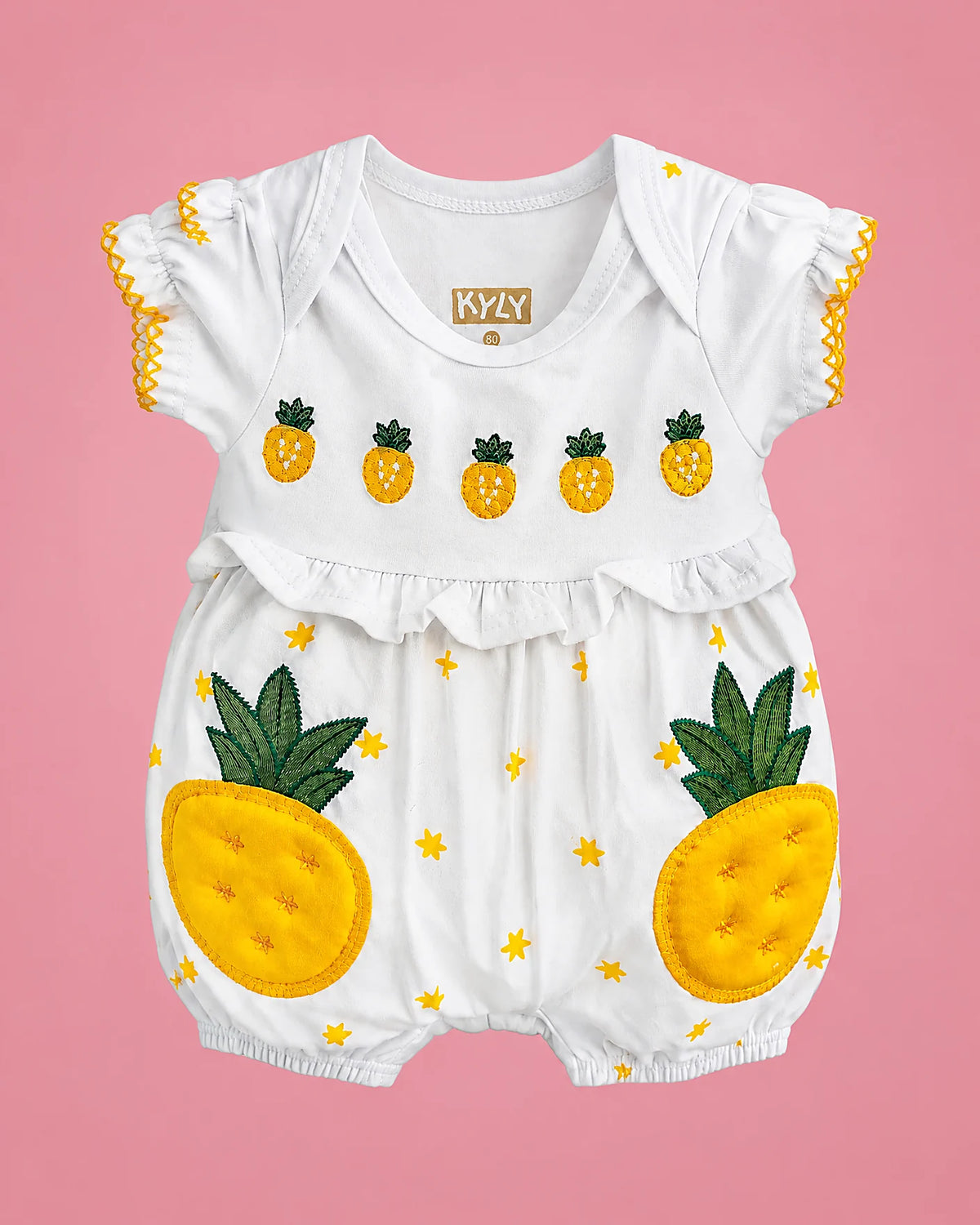 Ropa de bebé niña blanca con piñas y estrellitas amarillas, vista de frente | JR Baby Center
