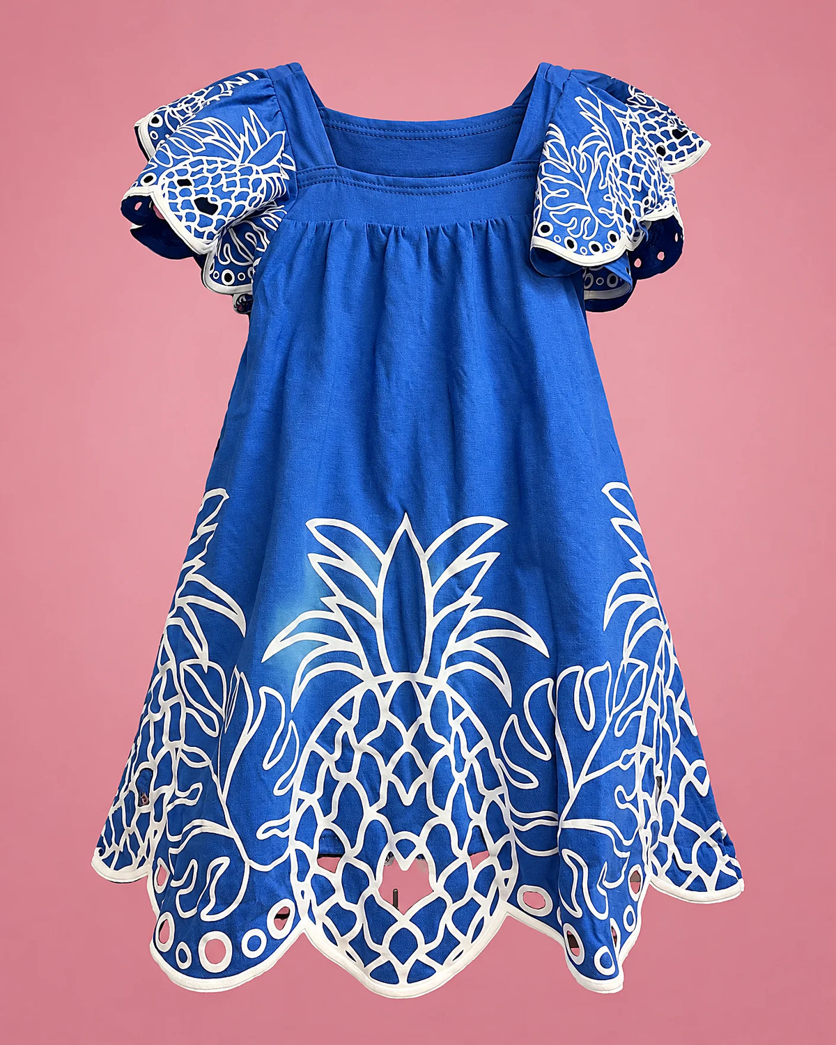 Vestido azul con piñas blancas y ruedo calado para niña, vista de espalda | JR Baby Center