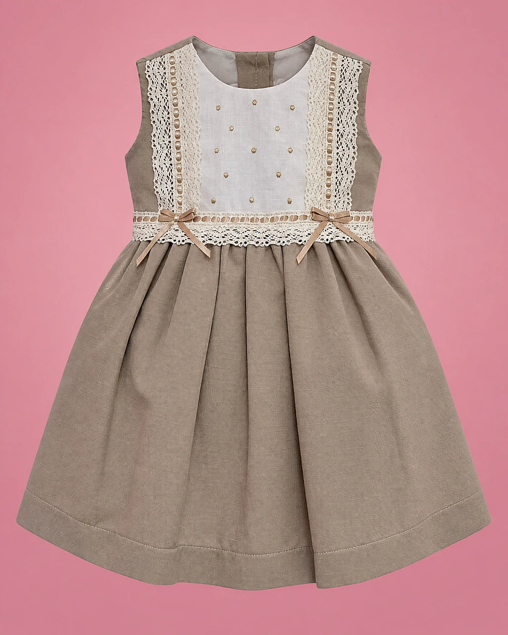 Vestido beige con pechera blanca de encaje y lazo para bebé niña, vista de frente | JR Baby Center