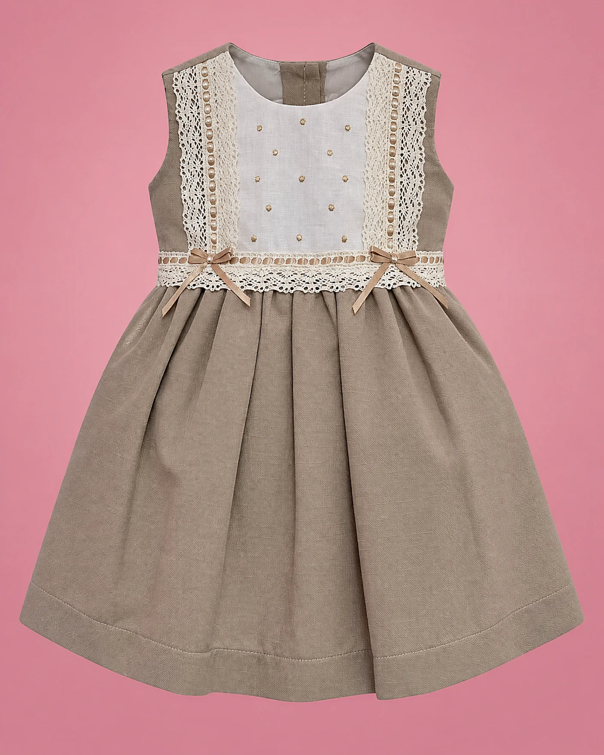 Vestido beige con pechera blanca de encaje y lazo para bebé niña, vista de frente | JR Baby Center