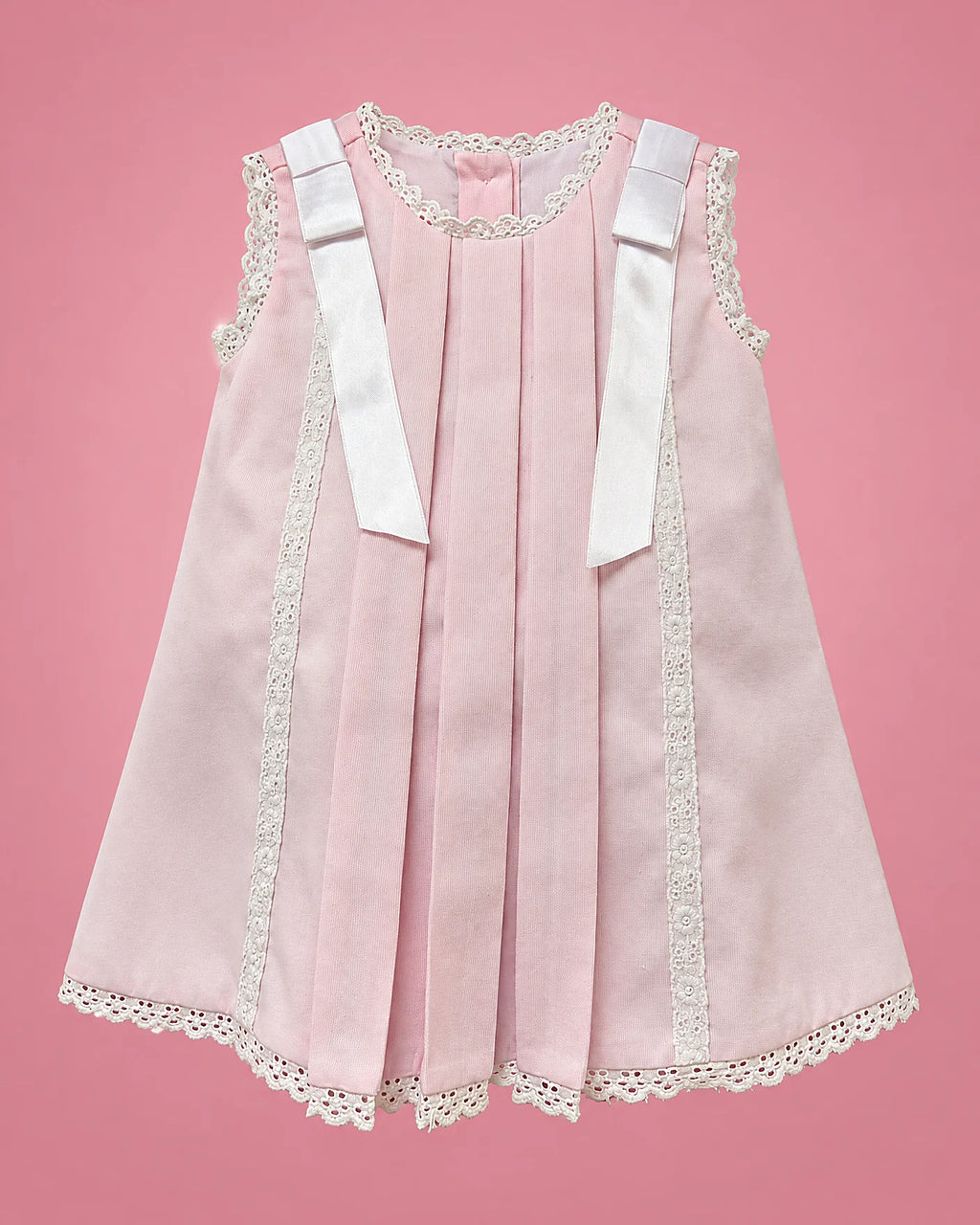 Vestido rosado claro con pliegues y encaje para bebé niña, vista de frente | JR Baby Center