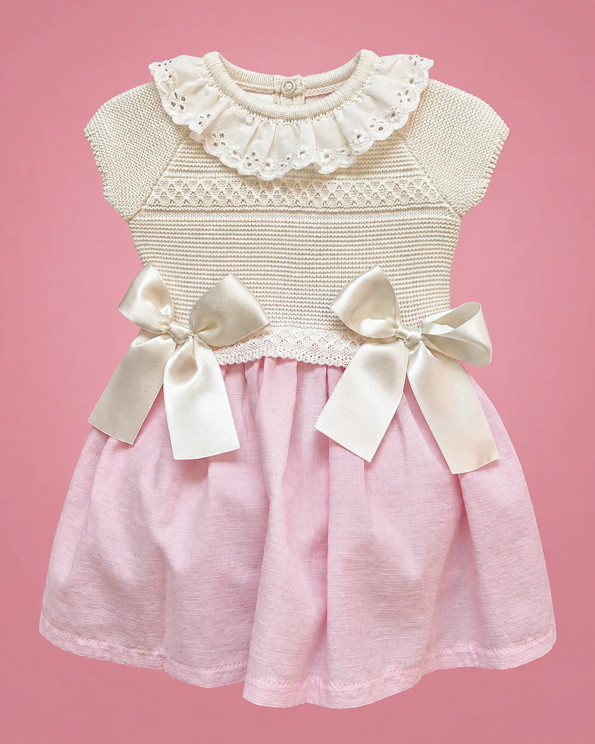 Vestido crema con falda rosada, cuello de volante y lazos para bebé niña, vista de frente | JR Baby Center