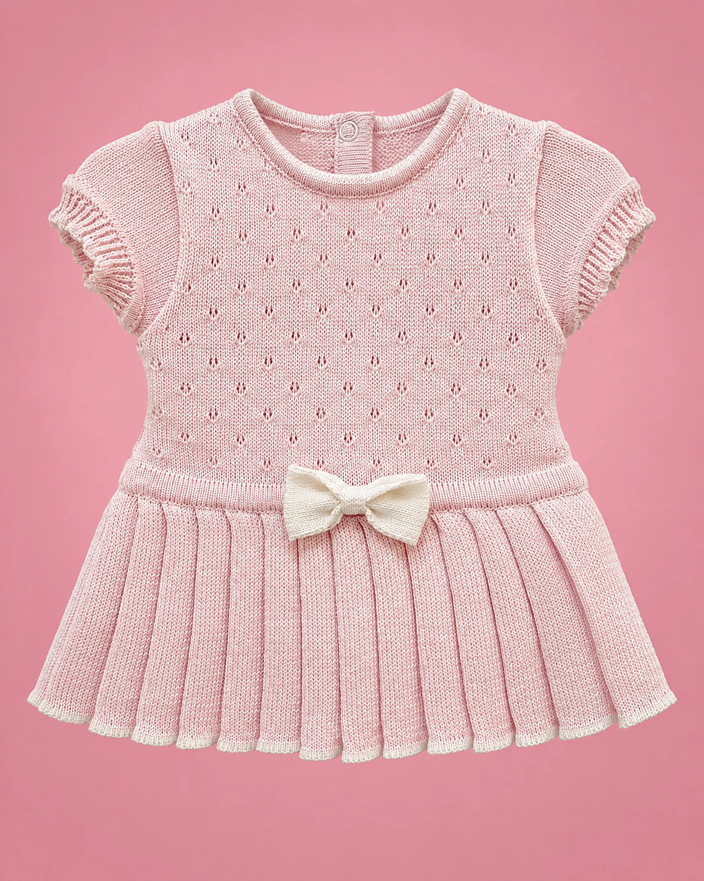 Vestido rosado con calados, falda plisada y lacito crema para bebé niña, vista de frente | JR Baby Center