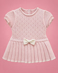 Vestido rosado con calados, falda plisada y lacito crema para bebé niña, vista de frente | JR Baby Center
