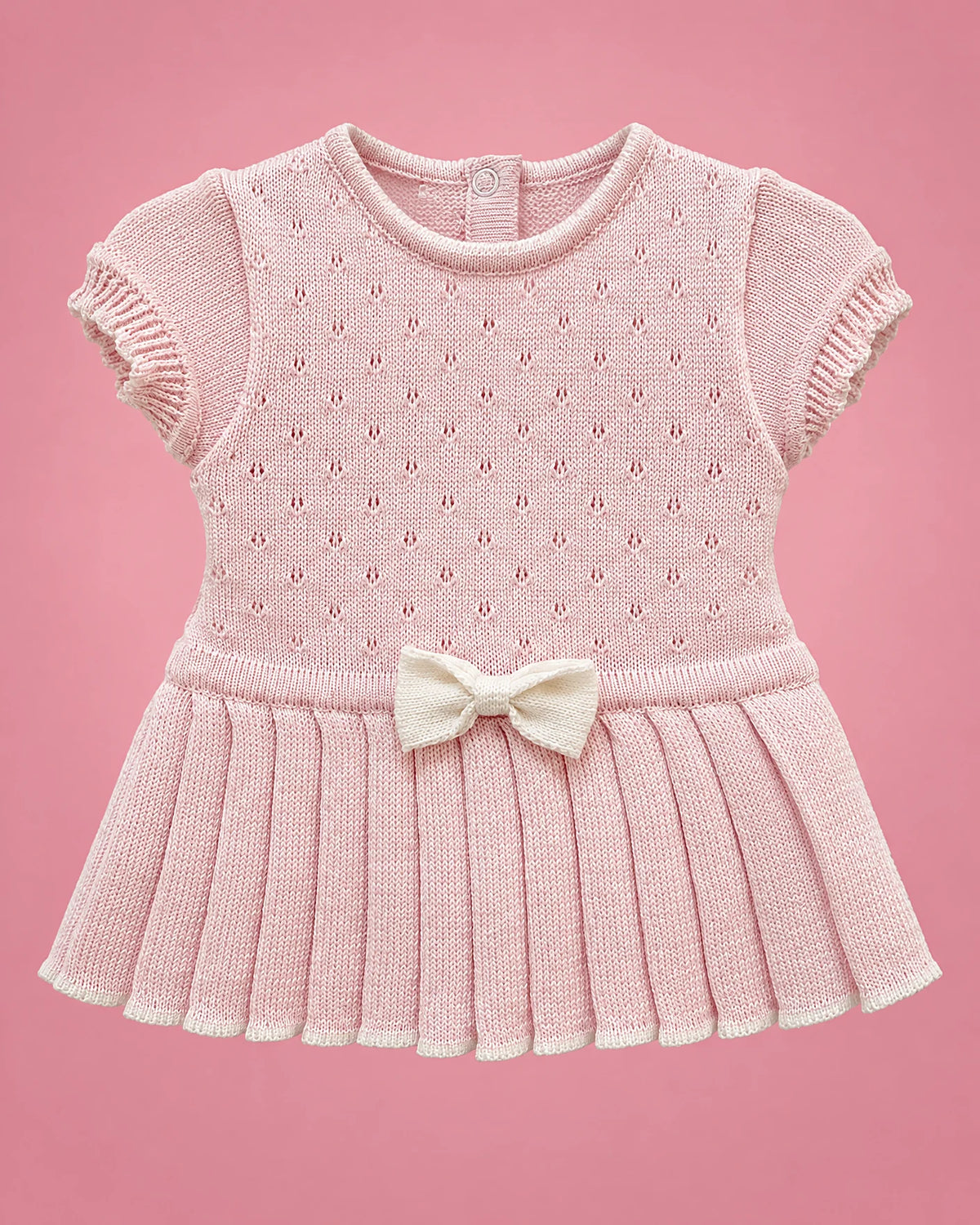 Vestido rosado con calados, falda plisada y lacito crema para bebé niña, vista de frente | JR Baby Center